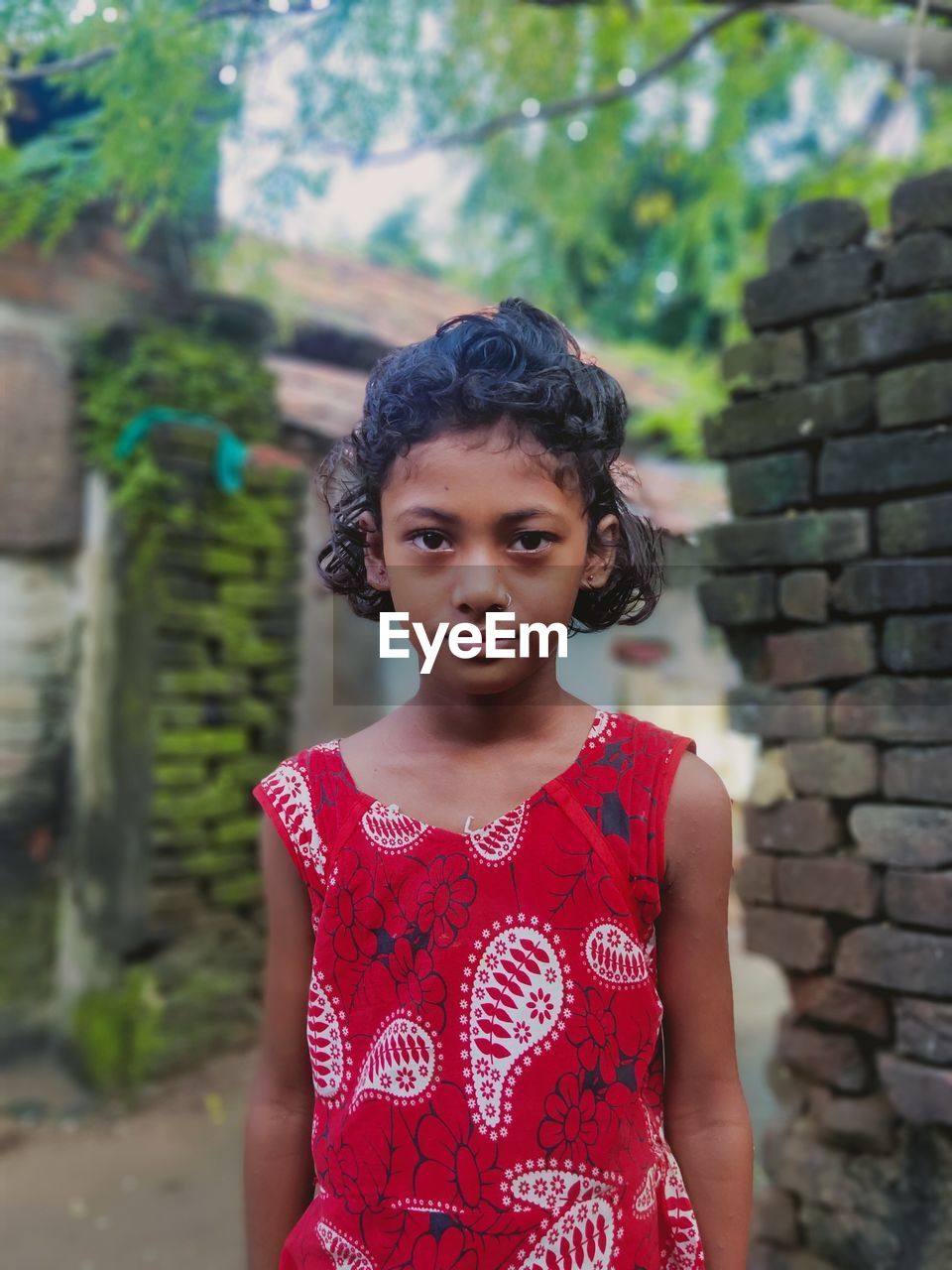 Portrait of girl standing against brick wall