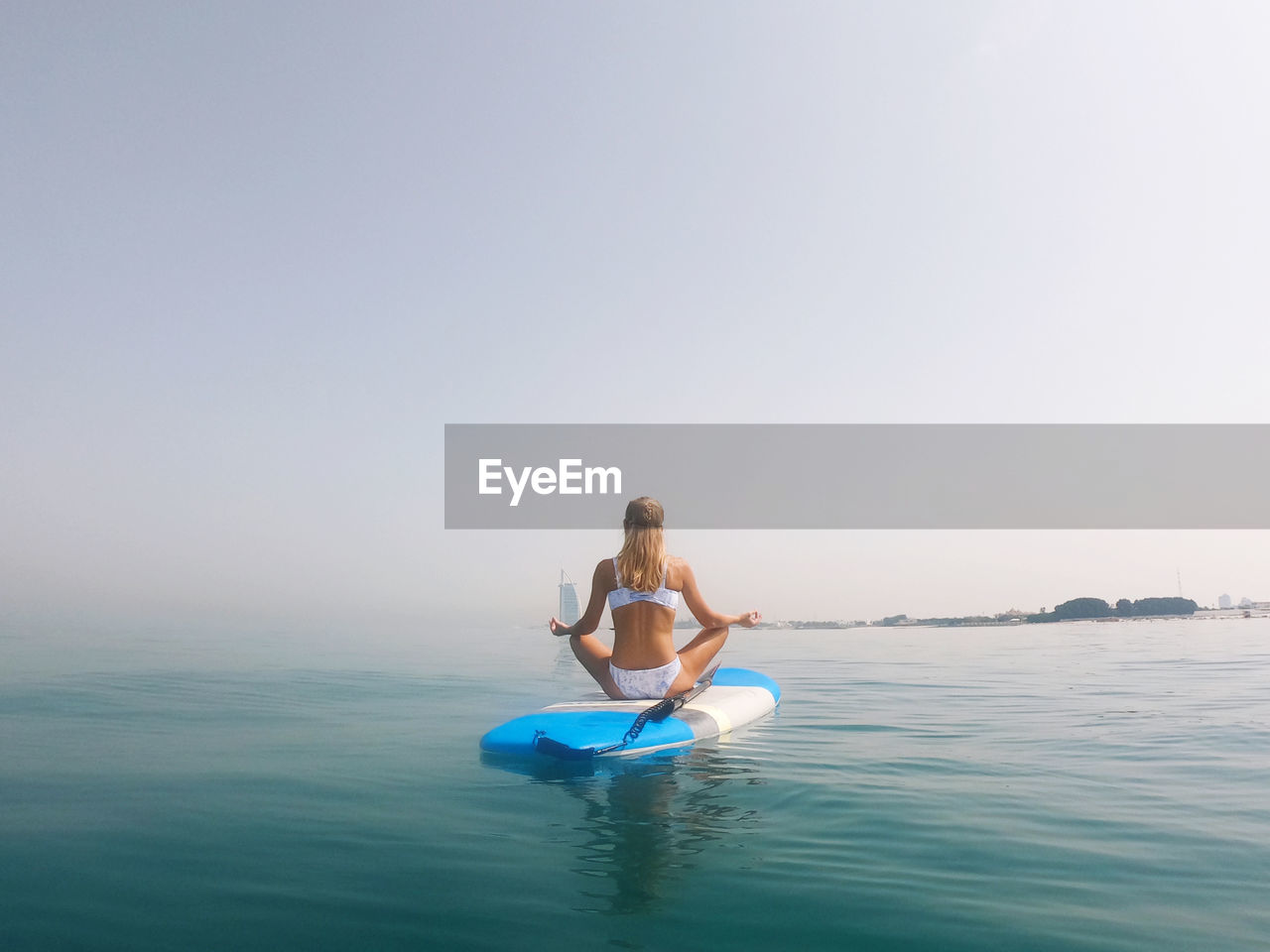 Woman meditating on the paddle board