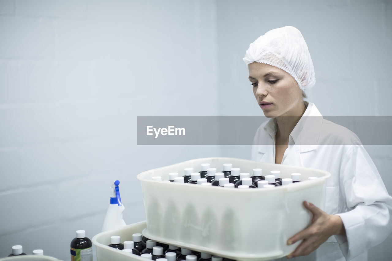Woman carrying box of medical supplies in medical factory