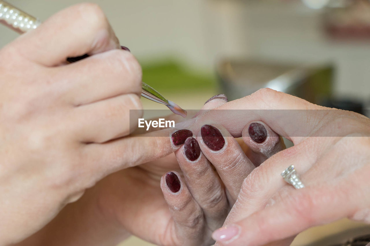 Close-up of hand giving manicure of customer