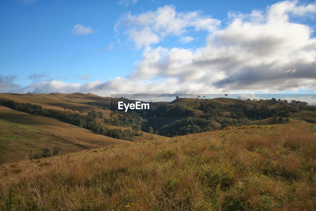 Scenic view of landscape and field against cloudy sky