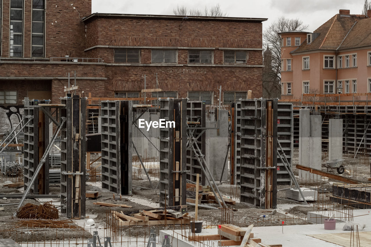 Old building by construction site in city