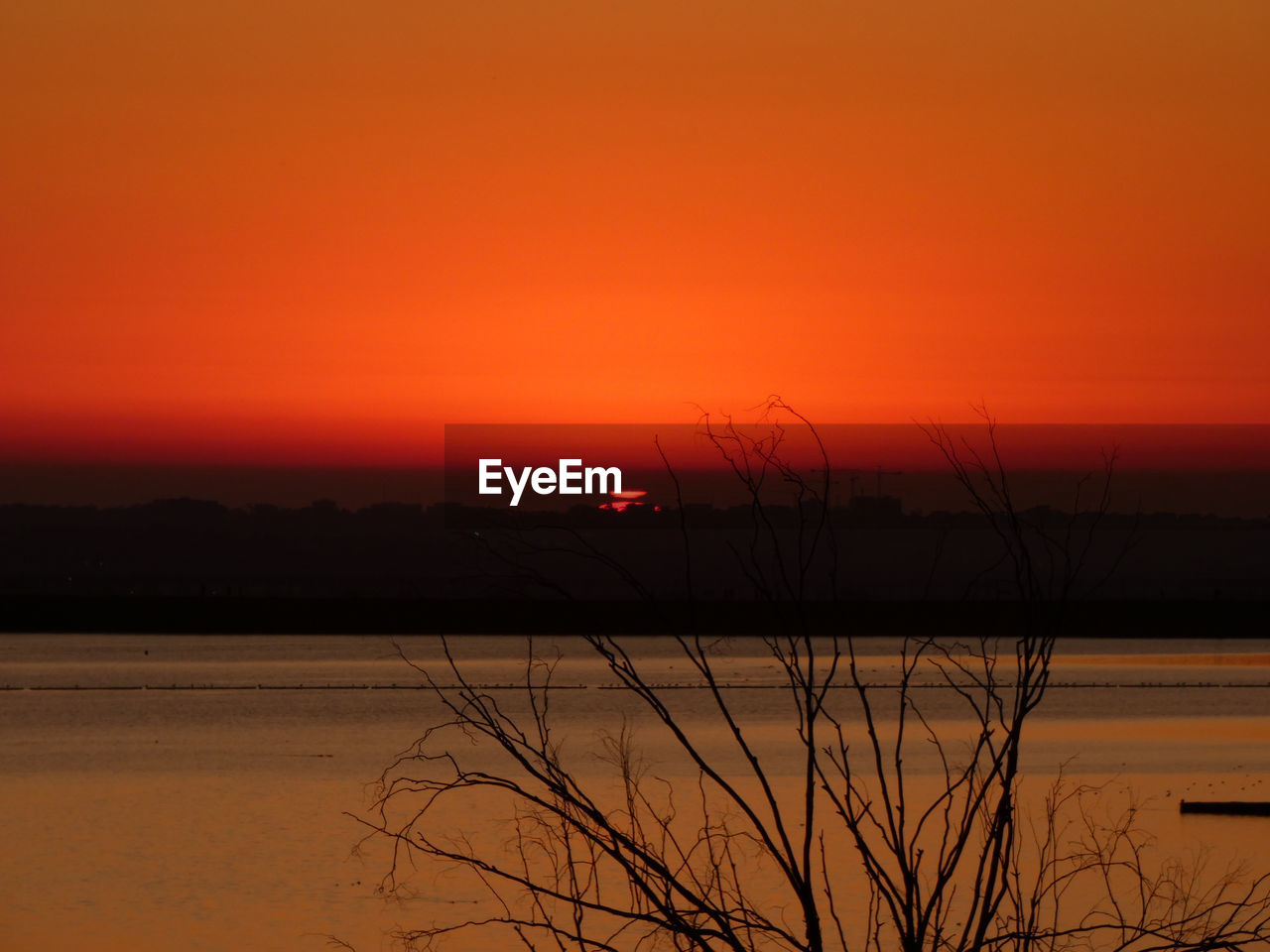 SCENIC VIEW OF LAKE AGAINST ORANGE SKY