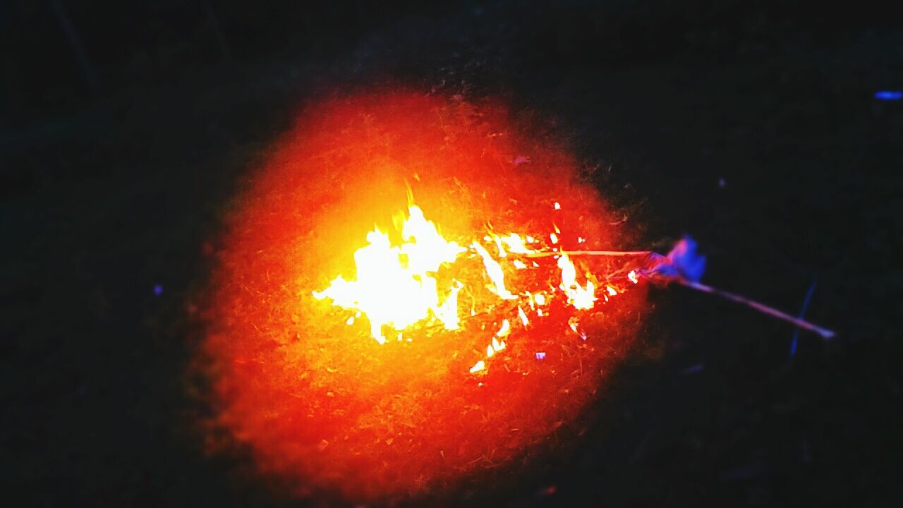 VIEW OF LIT CANDLE IN DARK ROOM