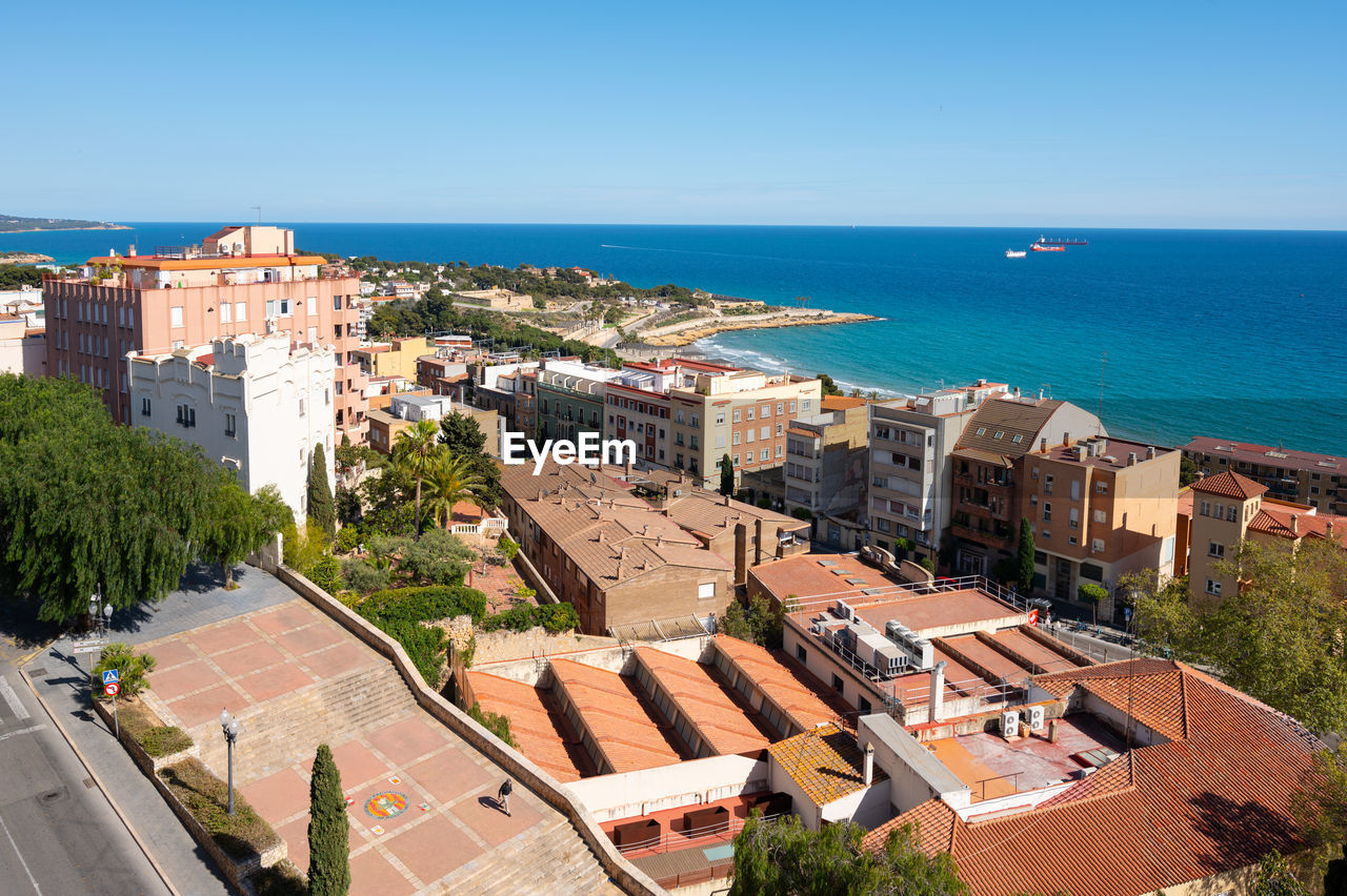 high angle view of townscape by sea against sky