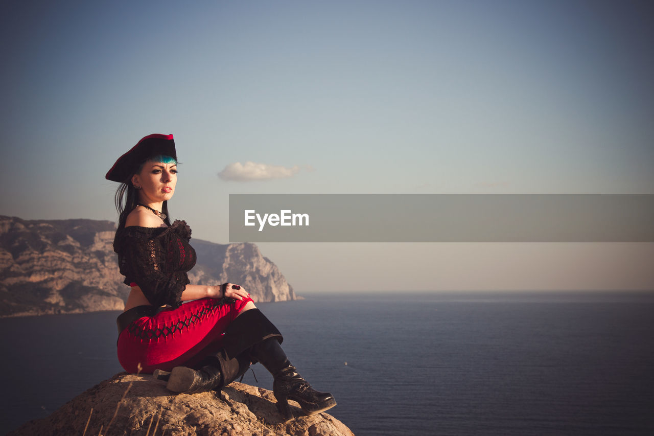 Portrait of a pirate woman at the beach. in anticipation of a pirate ship