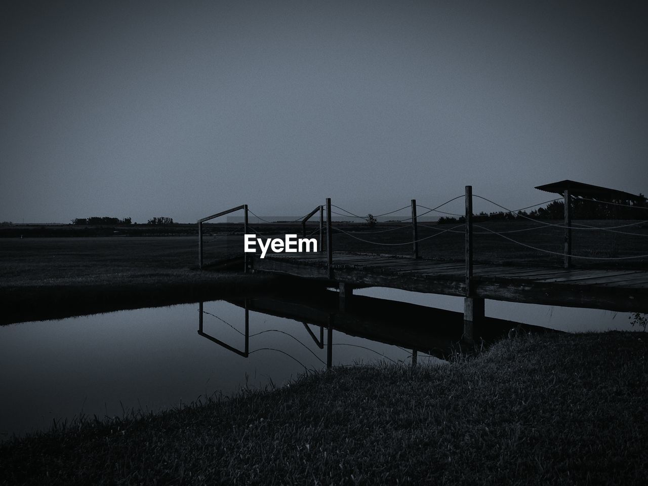 PIER ON FIELD AGAINST CLEAR SKY