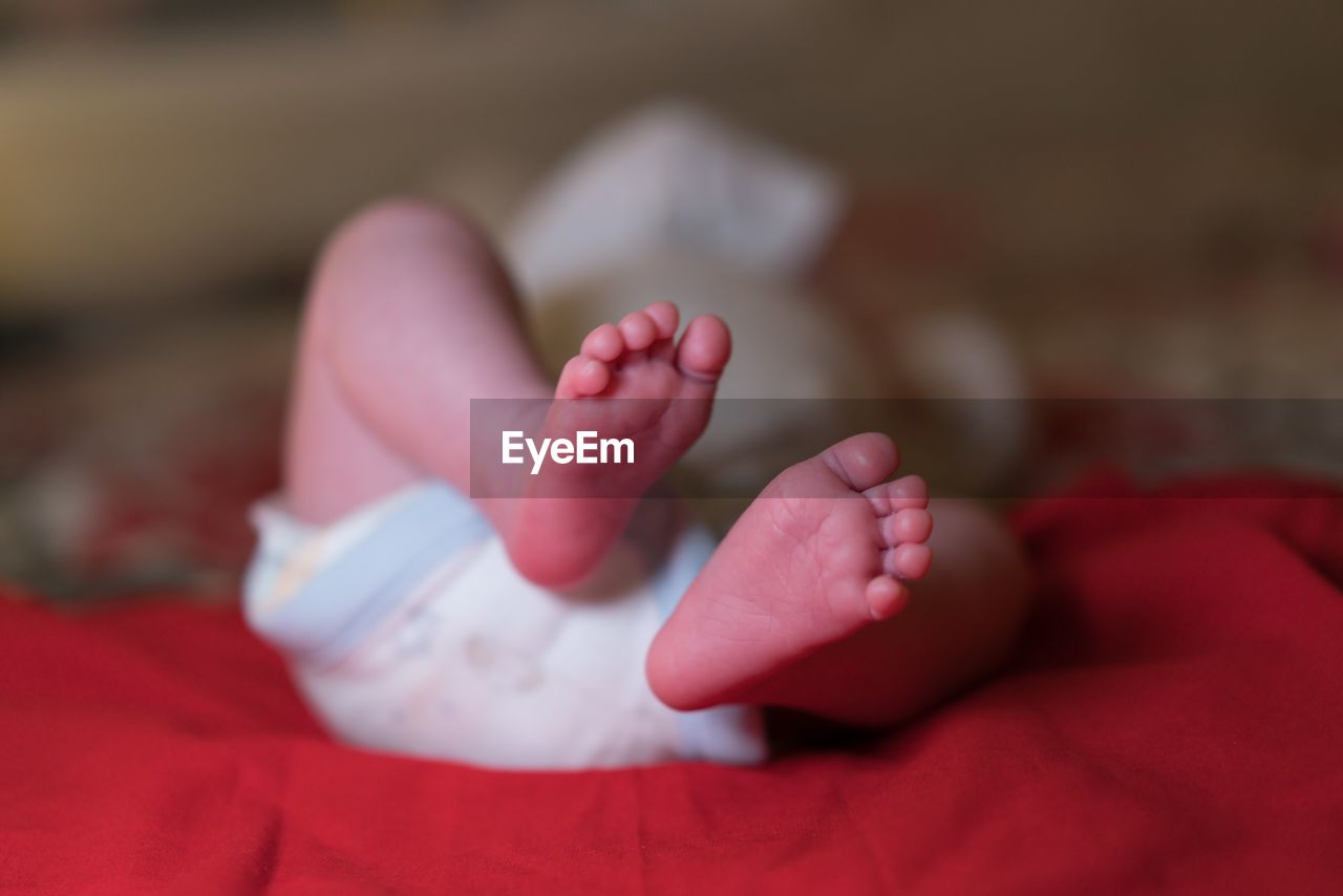 Close-up of newborn baby sleeping on bed at home