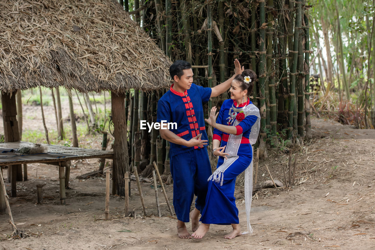 YOUNG COUPLE STANDING ON A TREE