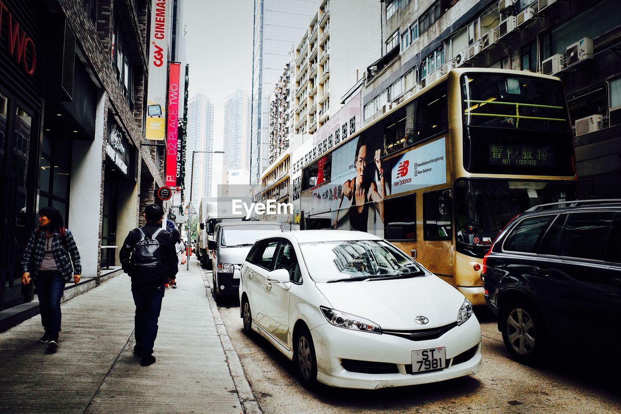 PEOPLE ON CITY STREET BY BUILDINGS