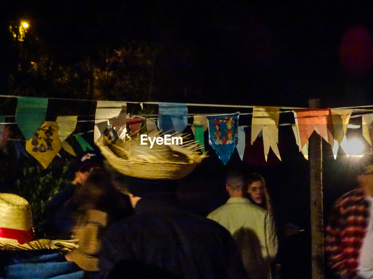 REAR VIEW OF PEOPLE SITTING AT MUSIC CONCERT