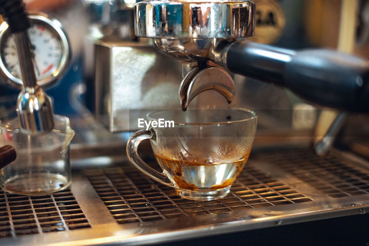 close-up of coffee pouring into glass on table