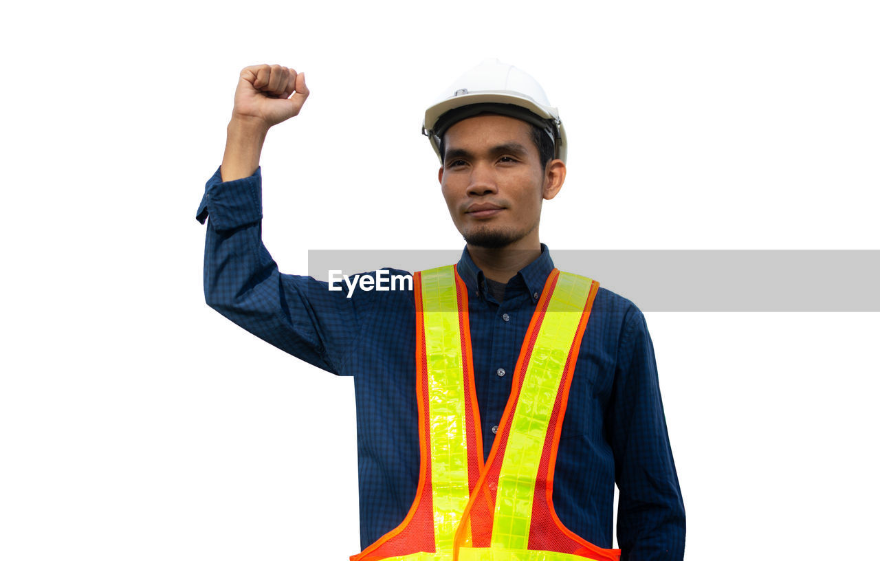 PORTRAIT OF YOUNG MAN STANDING ON WHITE BACKGROUND