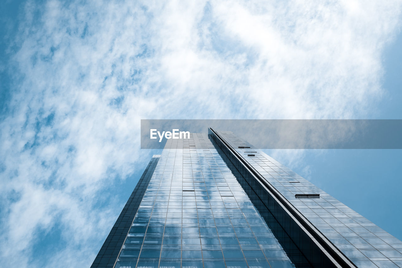 Low angle view of glass building against sky