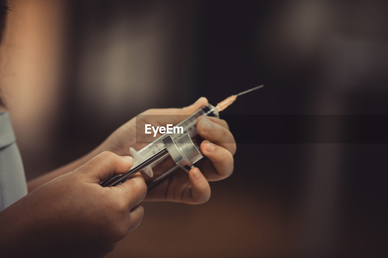 Close-up of doctor hands holding syringe