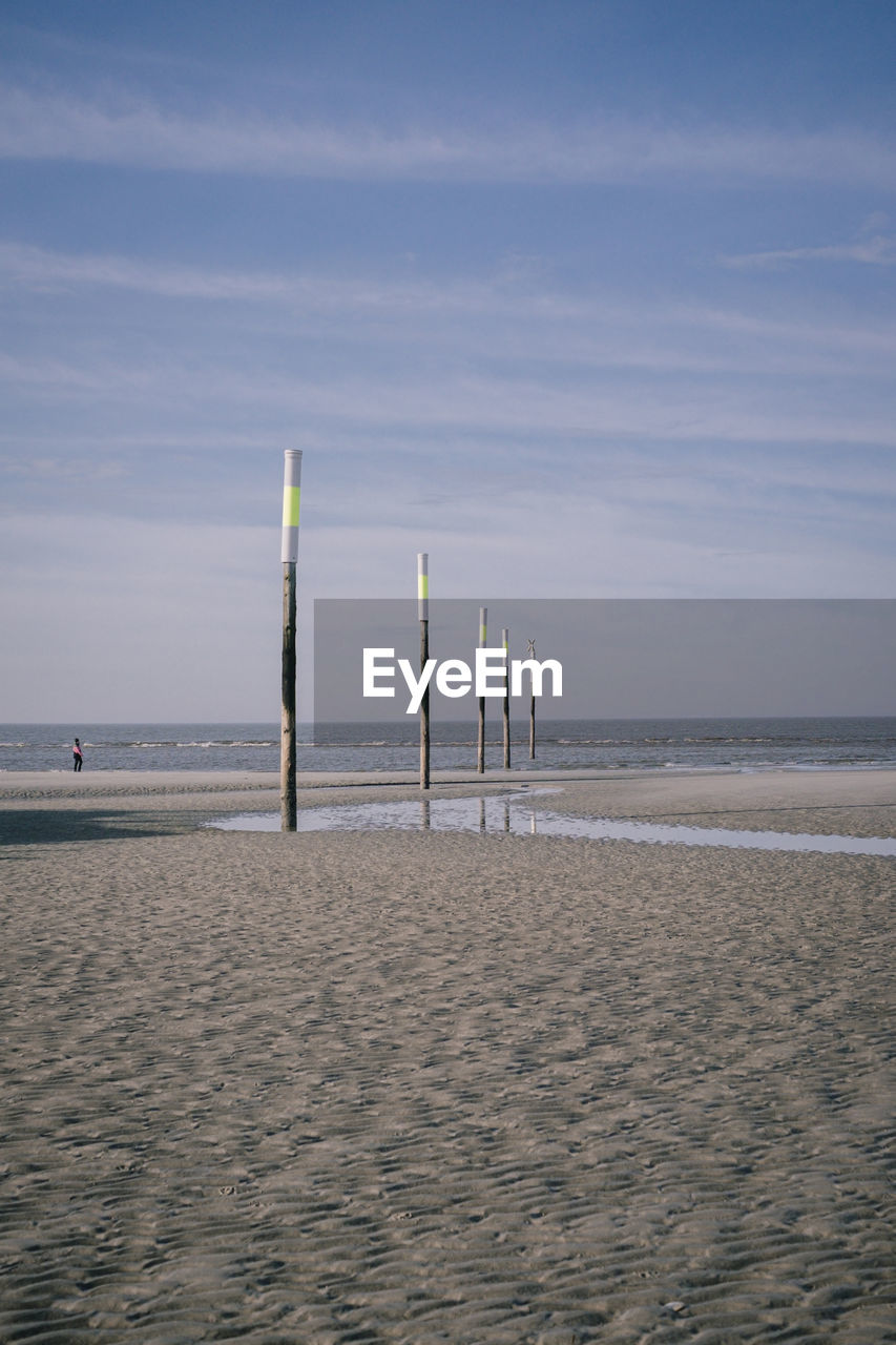 WOODEN POSTS ON BEACH