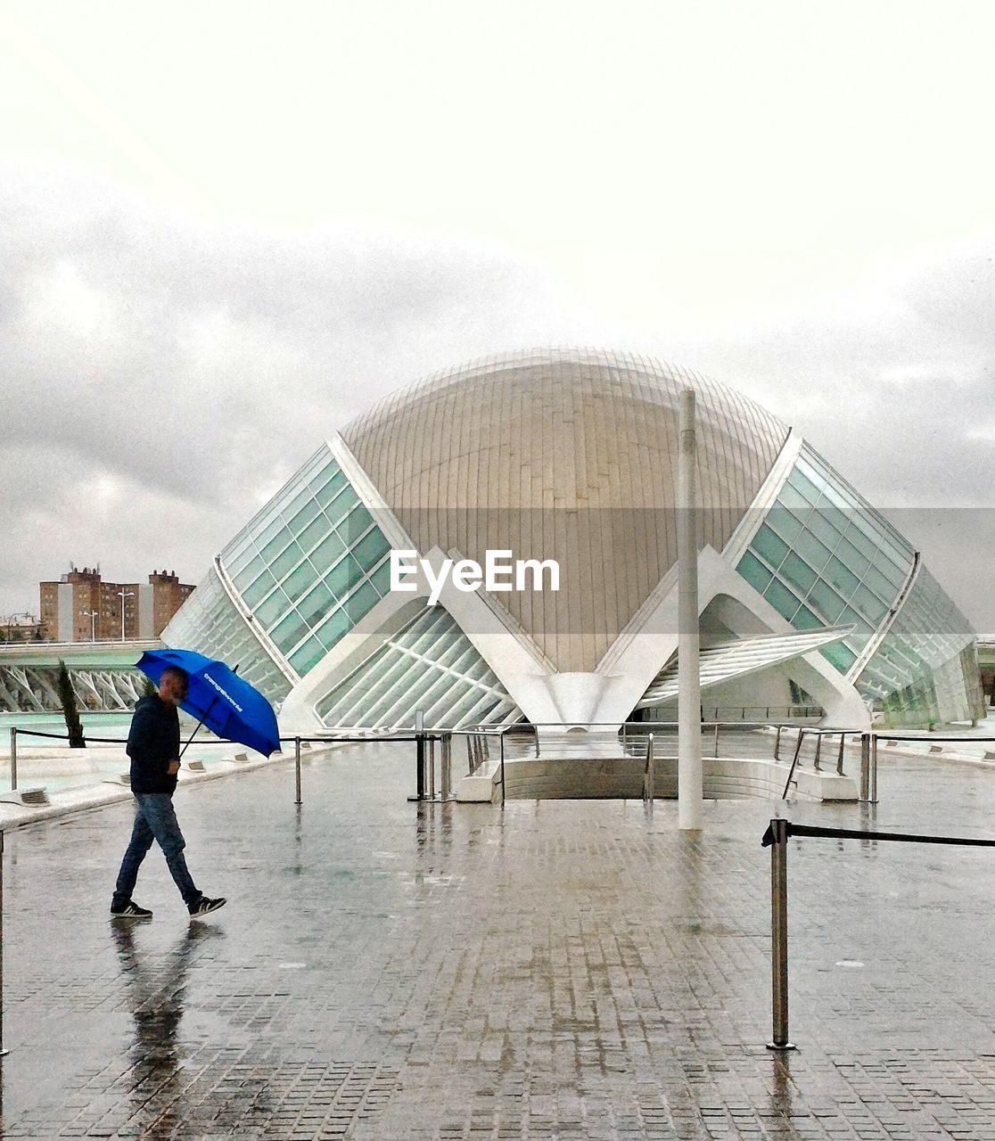 MAN WITH UMBRELLA AGAINST SKY