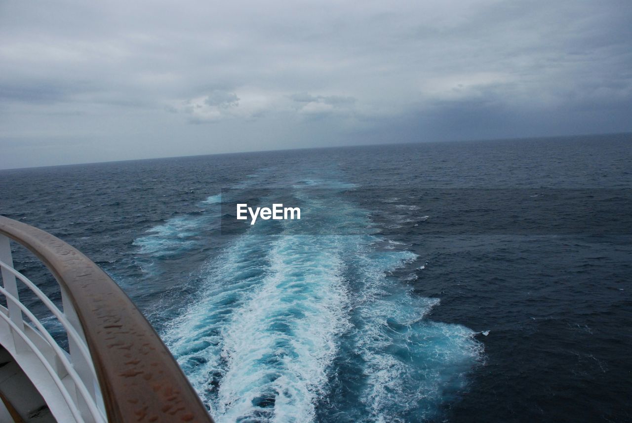 Ship wake in sea against sky