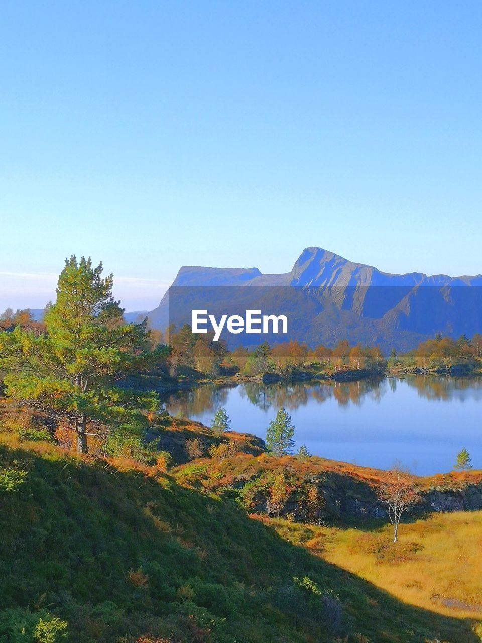 Scenic view of lake against clear blue sky