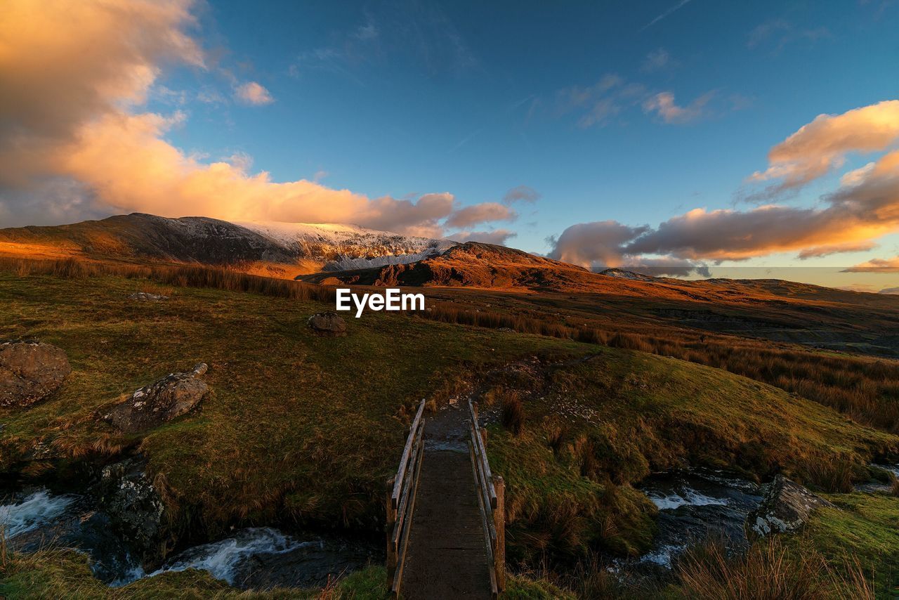 Bridge over river against mountains