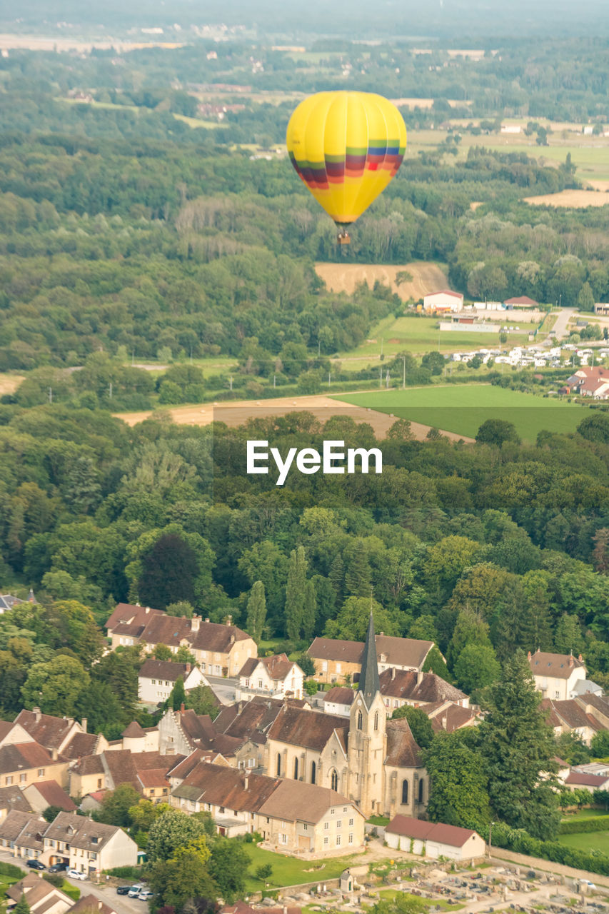 Hot air balloon flying over the village of voiteur in the jura