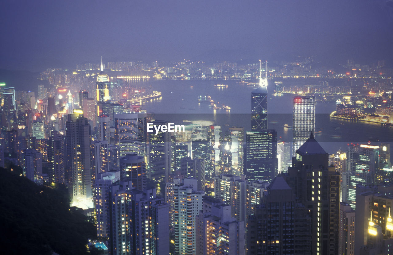 aerial view of illuminated cityscape against sky at night