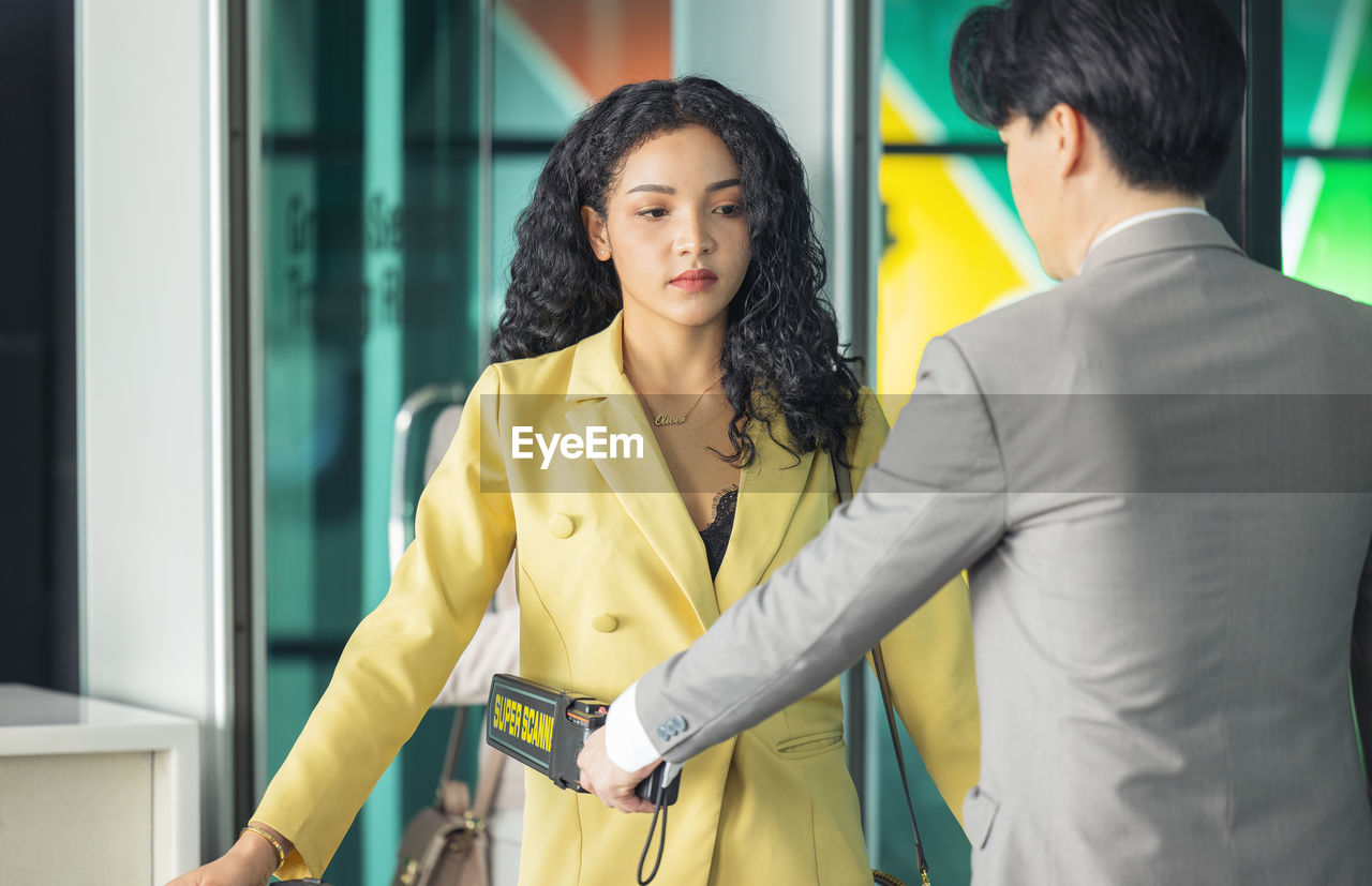 In the airport, people are going through the physical screening and luggage scanning procedures.