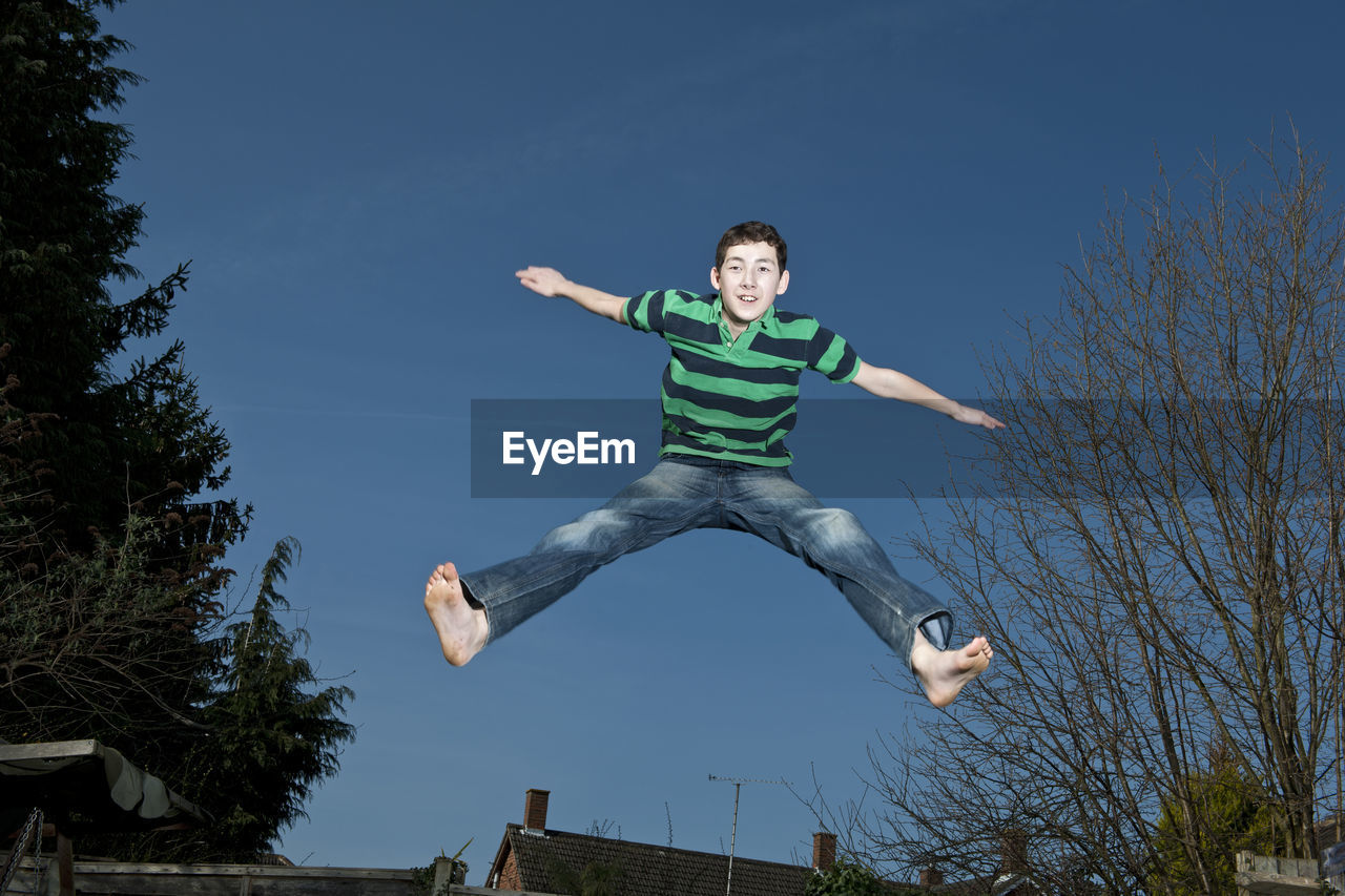 Boy jumping on trampoline in woking - england