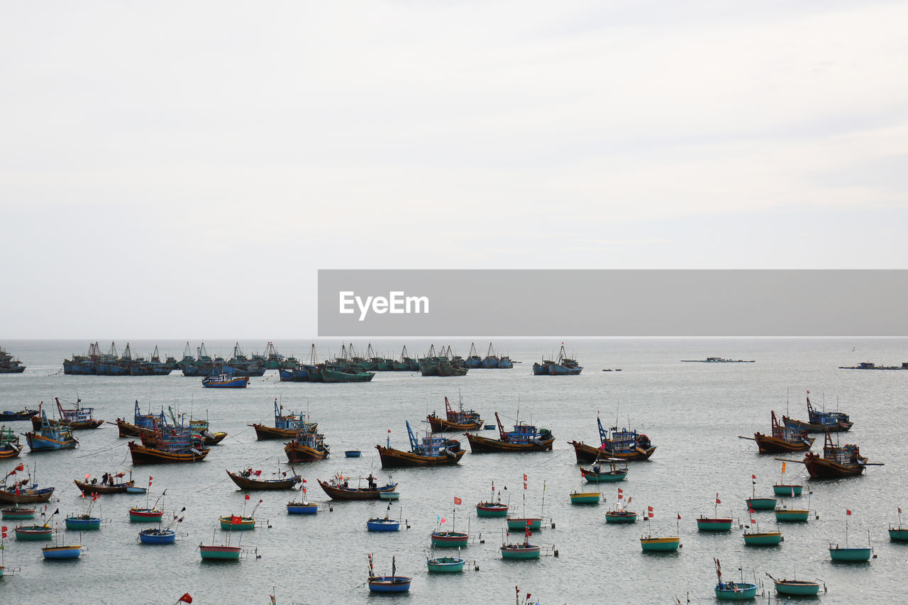 HIGH ANGLE VIEW OF BOATS ON SEA AGAINST SKY