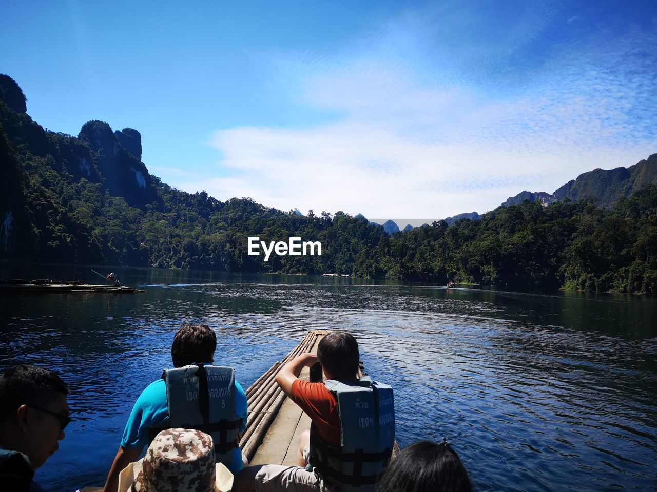 PEOPLE ON LAKE AGAINST MOUNTAIN