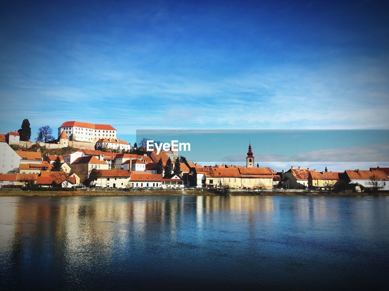 Lake with built structures against blue sky