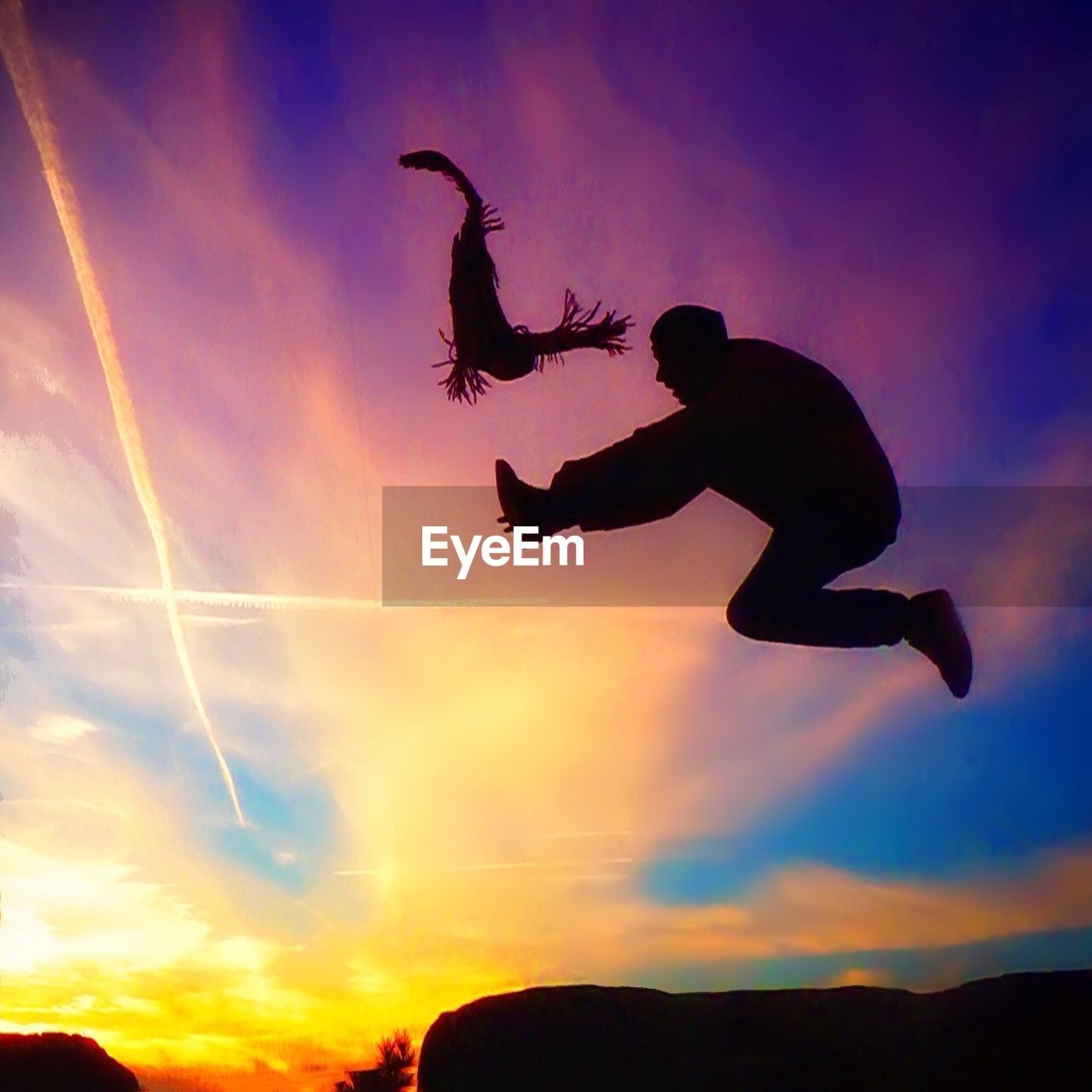 LOW ANGLE VIEW OF WOMAN JUMPING IN SKY