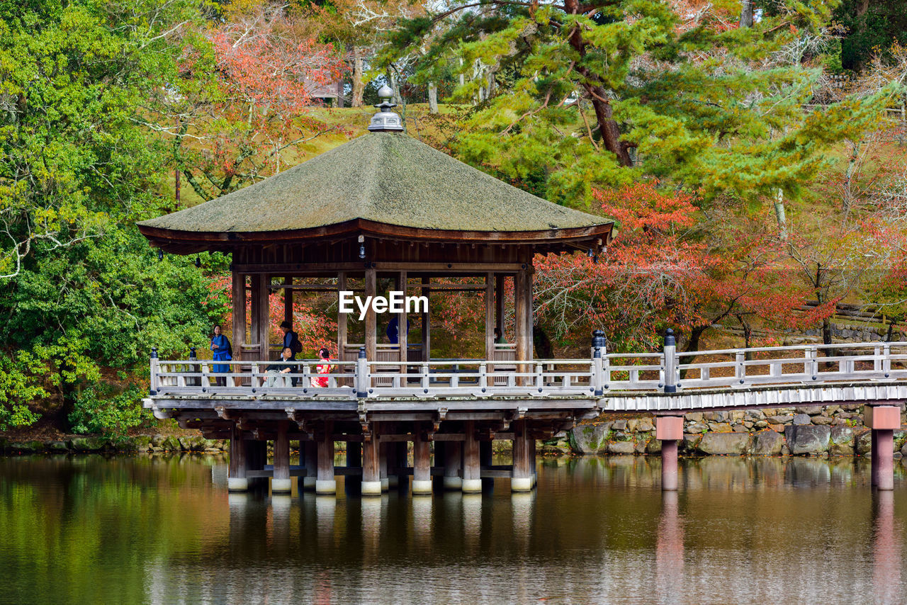 Footbridge over lake against trees during autumn