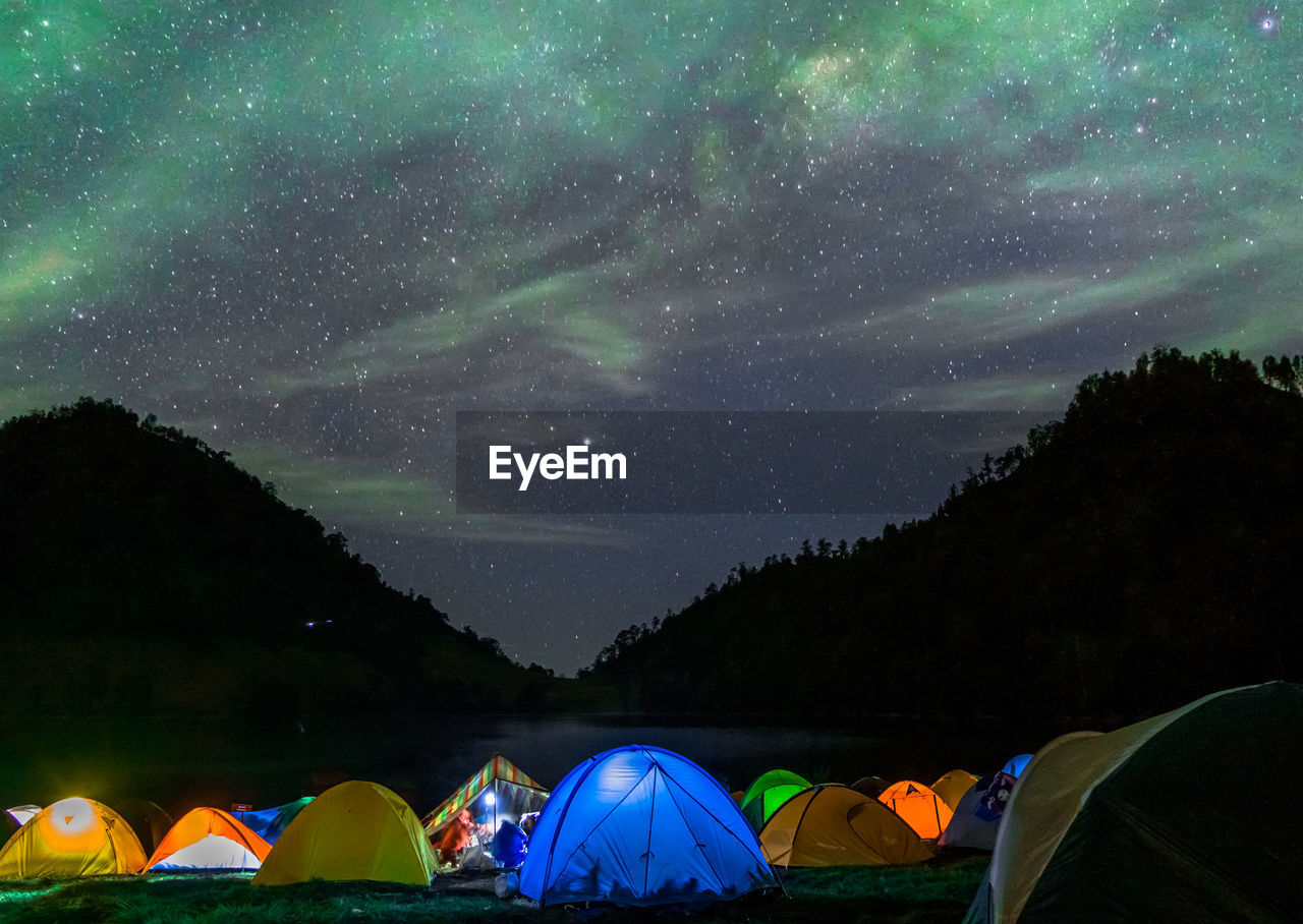 Scenic view of tents against sky at night