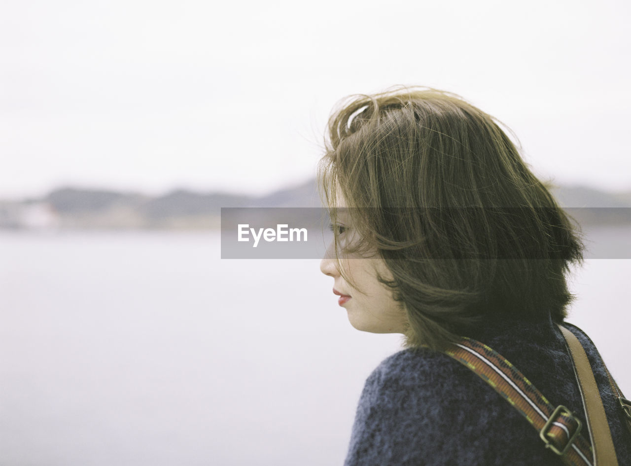 Rear view of thoughtful young woman at beach