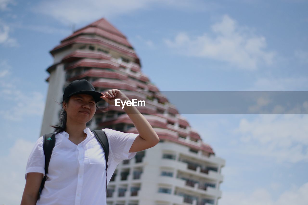 Low angle view of woman standing against built structure