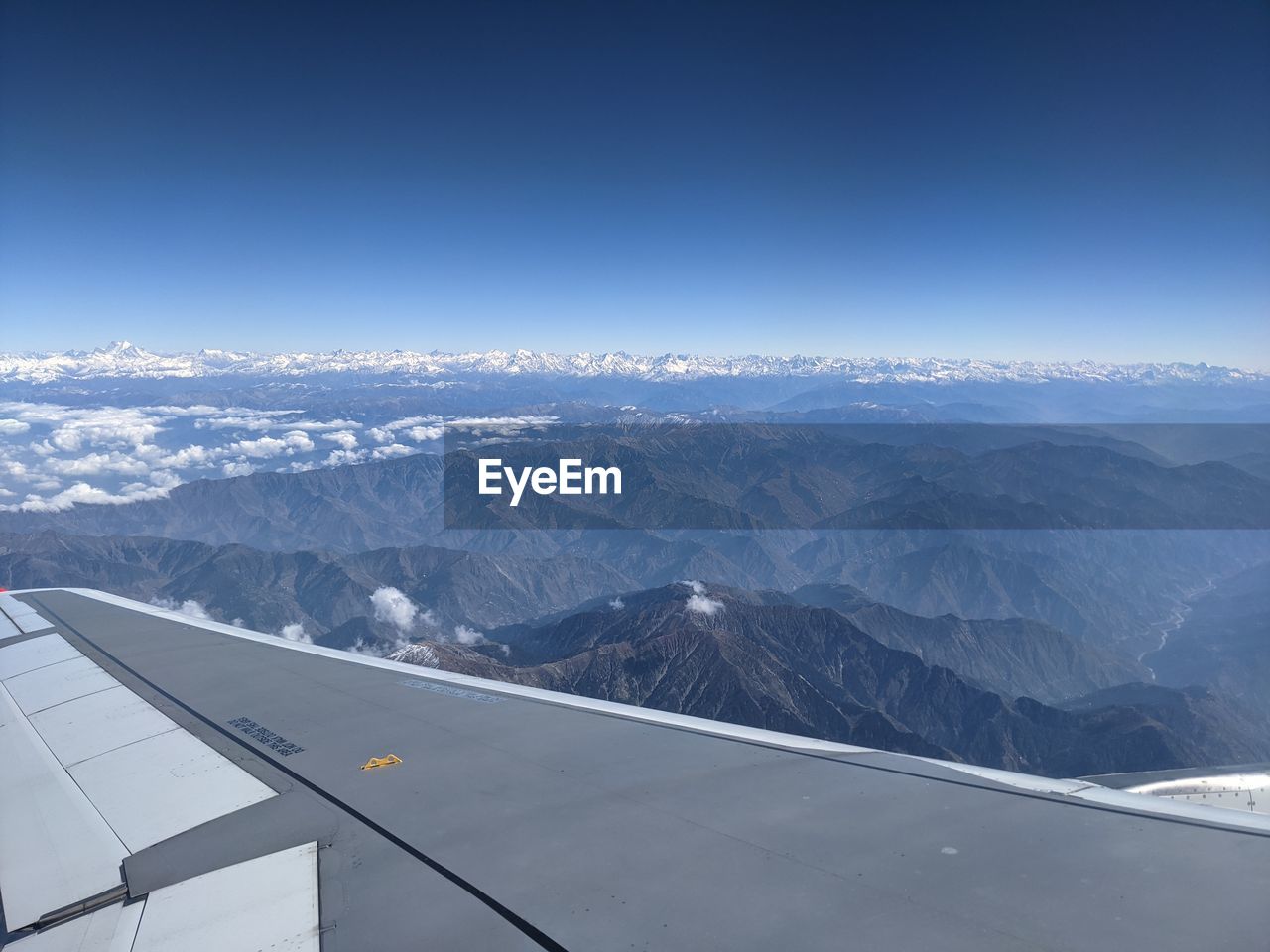 AERIAL VIEW OF SNOWCAPPED MOUNTAINS AGAINST SKY