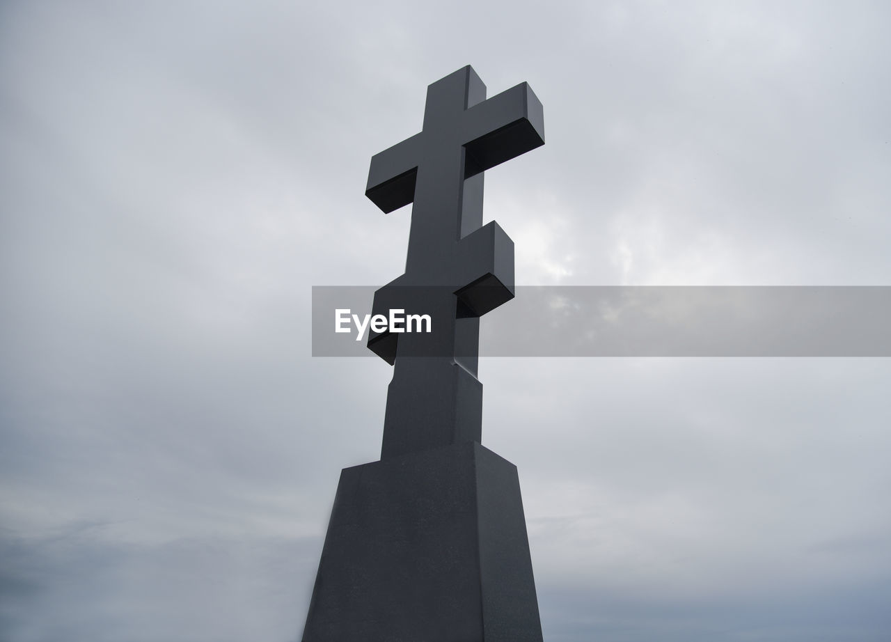 LOW ANGLE VIEW OF CROSS SCULPTURE AGAINST CLOUDY SKY