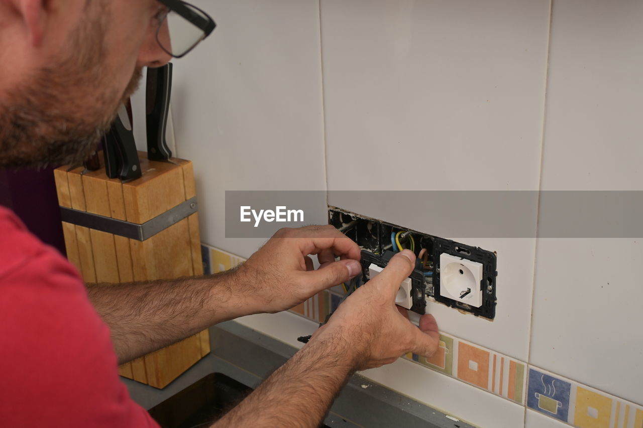 close-up of man working on wall