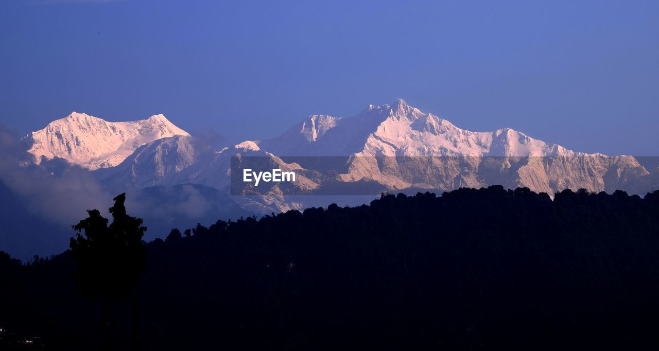 Scenic view of snowcapped mountains against clear sky