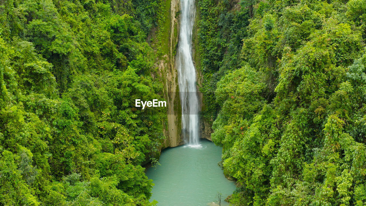Waterfall in the rainforest jungle from above. tropical mantayupan falls in mountain jungle. 