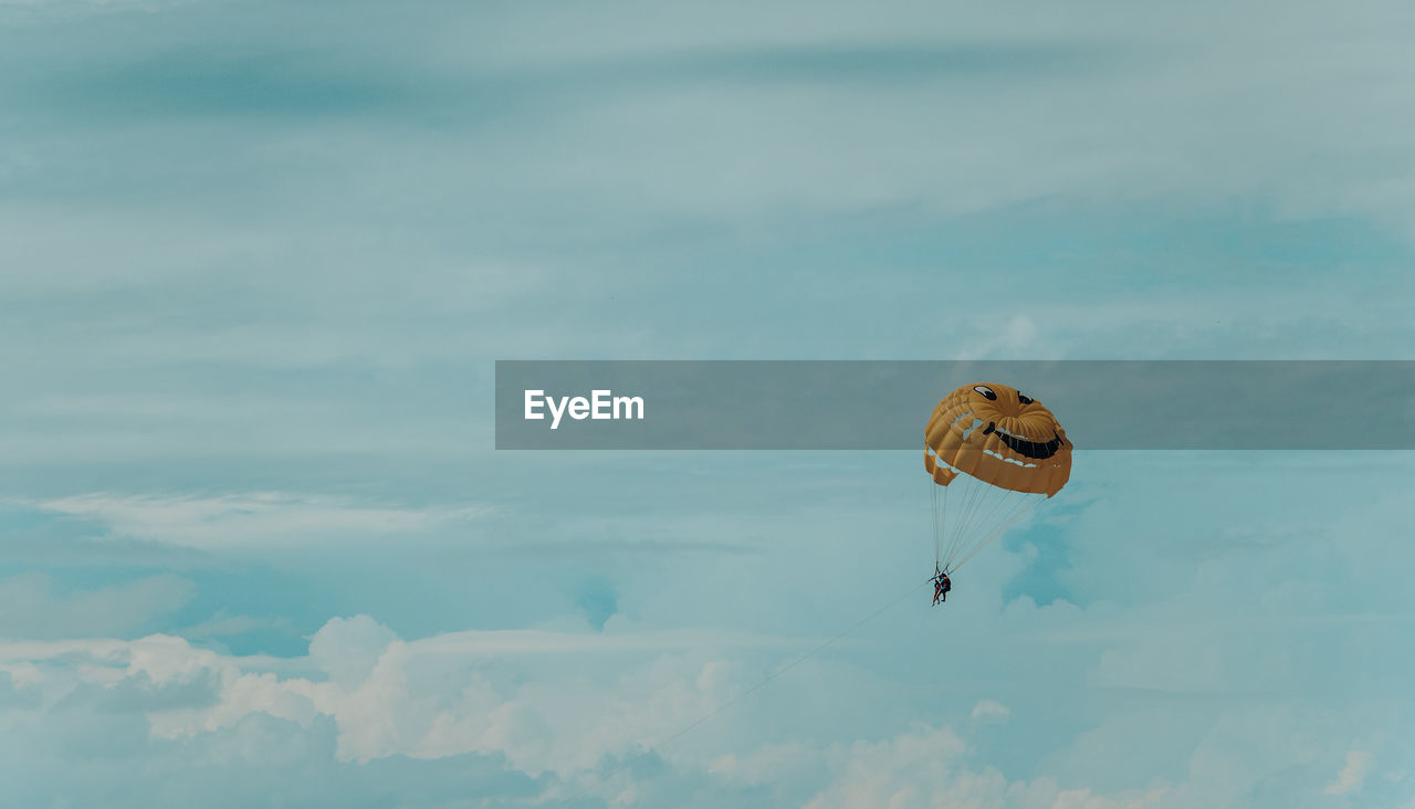 Low angle view of person paragliding against sky