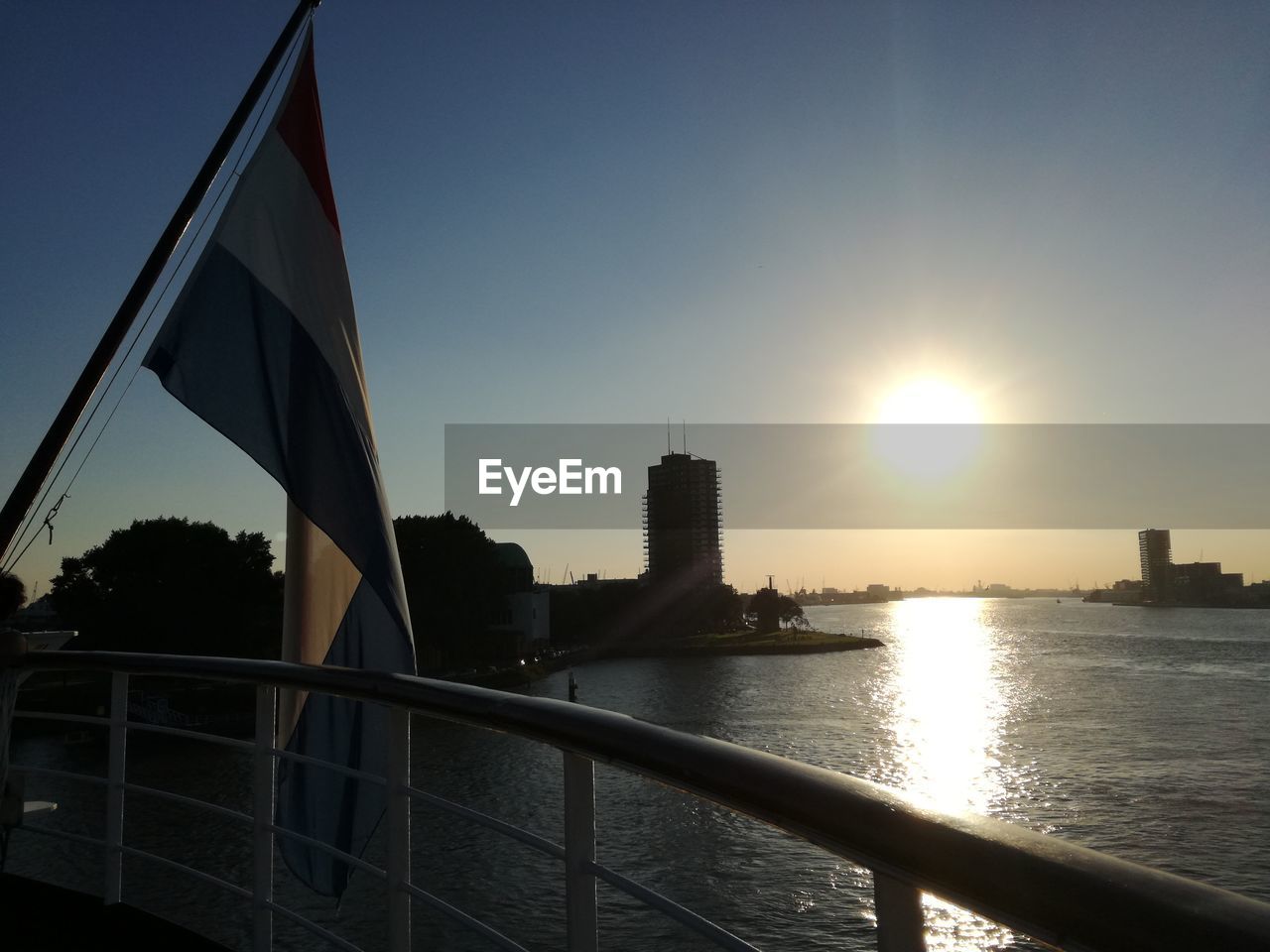 SUSPENSION BRIDGE OVER RIVER AT SUNSET