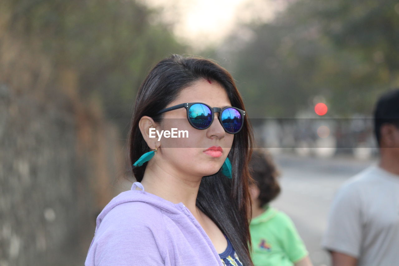 Close-up of beautiful young woman wearing sunglasses