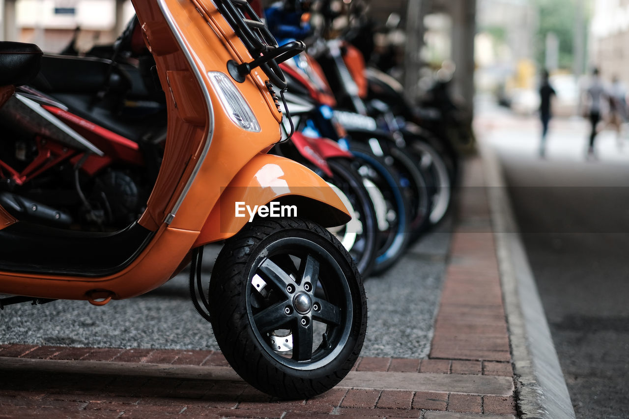 Close-up of motorcycle parked on street pavement