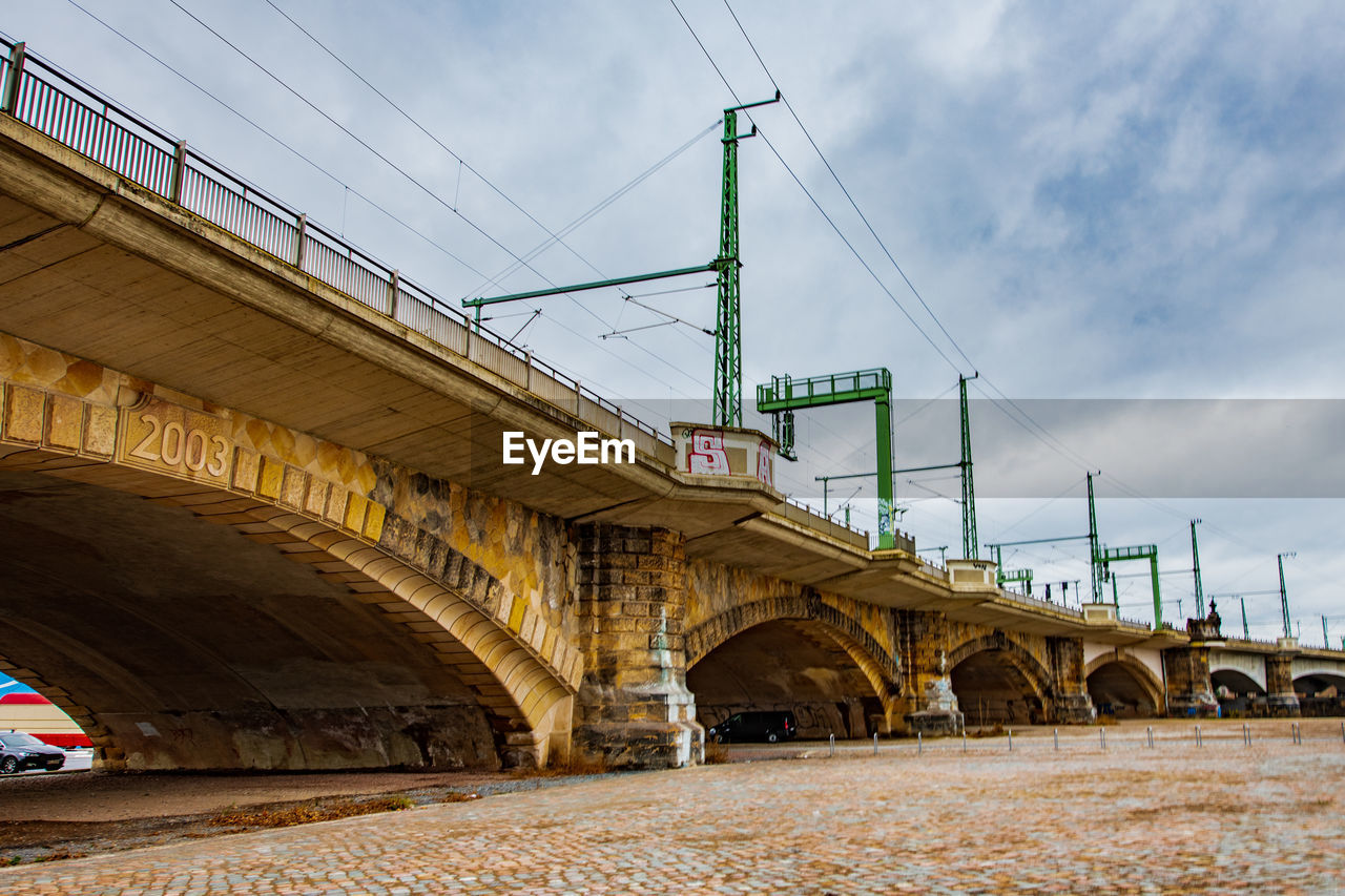 LOW ANGLE VIEW OF BRIDGE AGAINST CLOUDY SKY