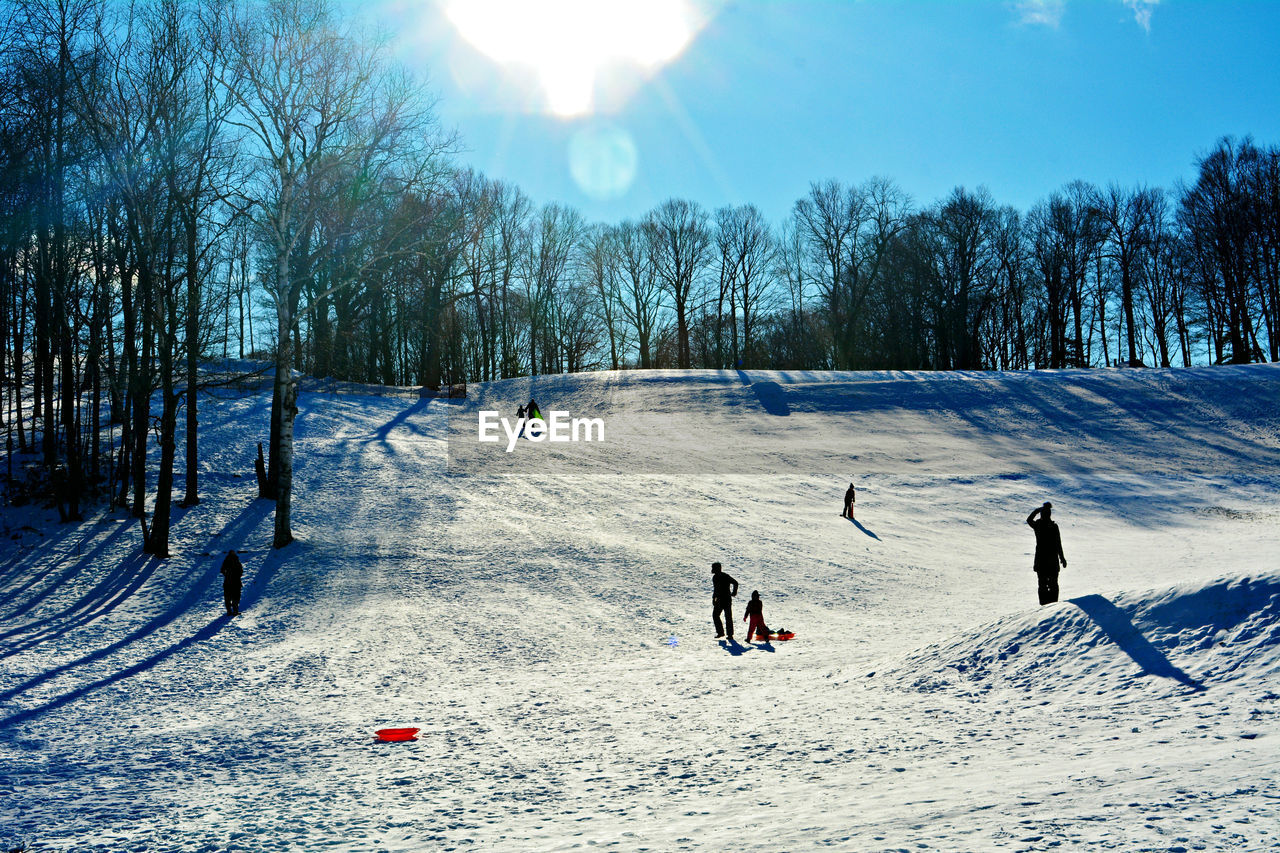 PEOPLE PLAYING ON FIELD DURING WINTER