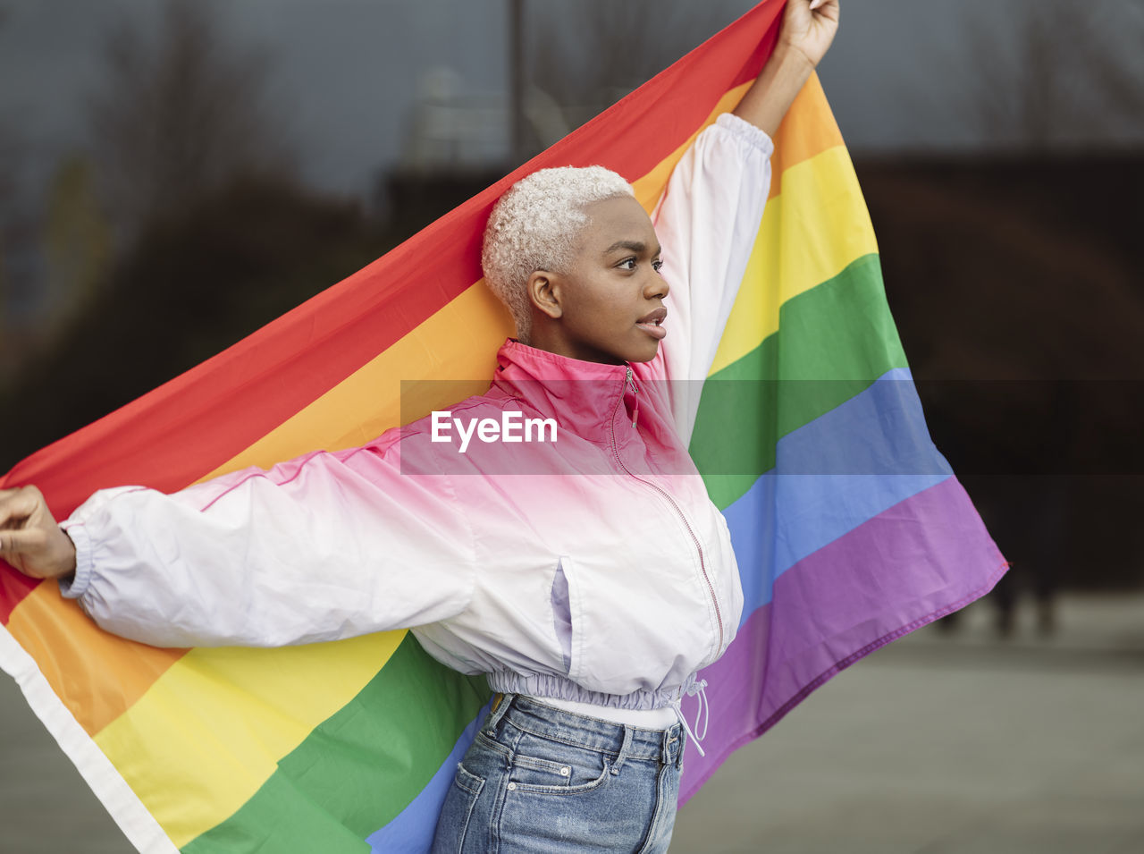 Confident lgbtqia woman holding rainbow flag