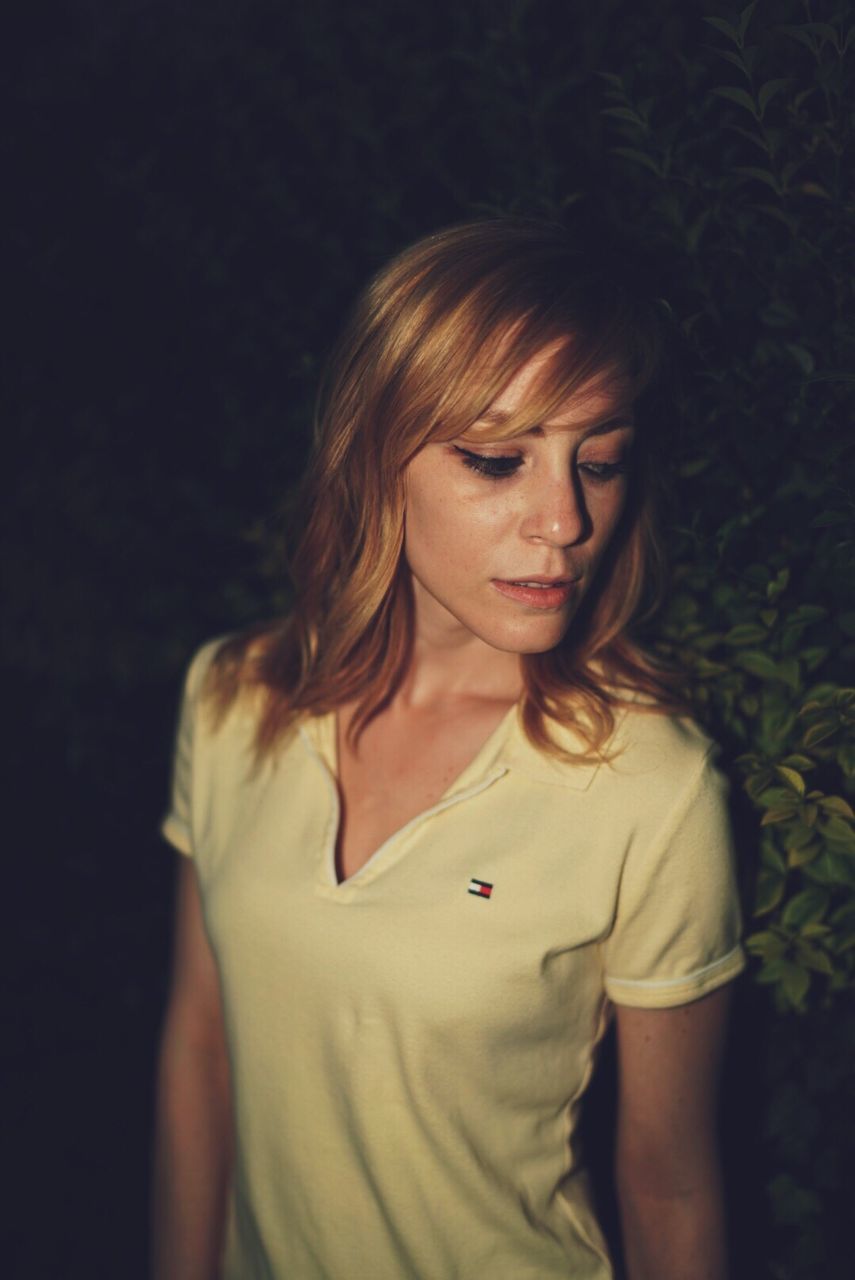 PORTRAIT OF BEAUTIFUL YOUNG WOMAN STANDING AGAINST WALL