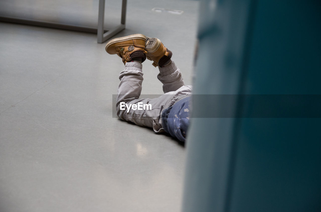 Low section of boy lying on floor